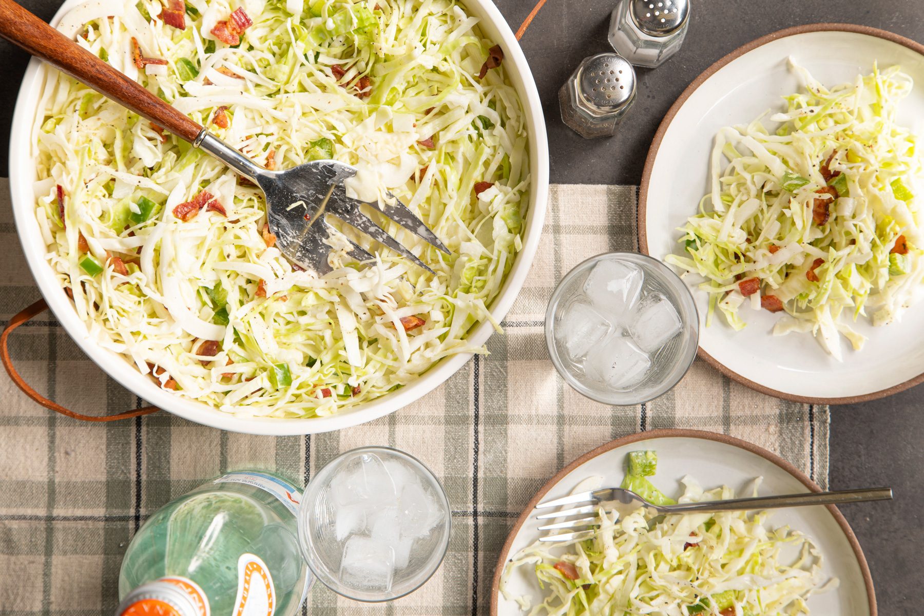 Cabbage Salad in serving bowl and plates over head shot