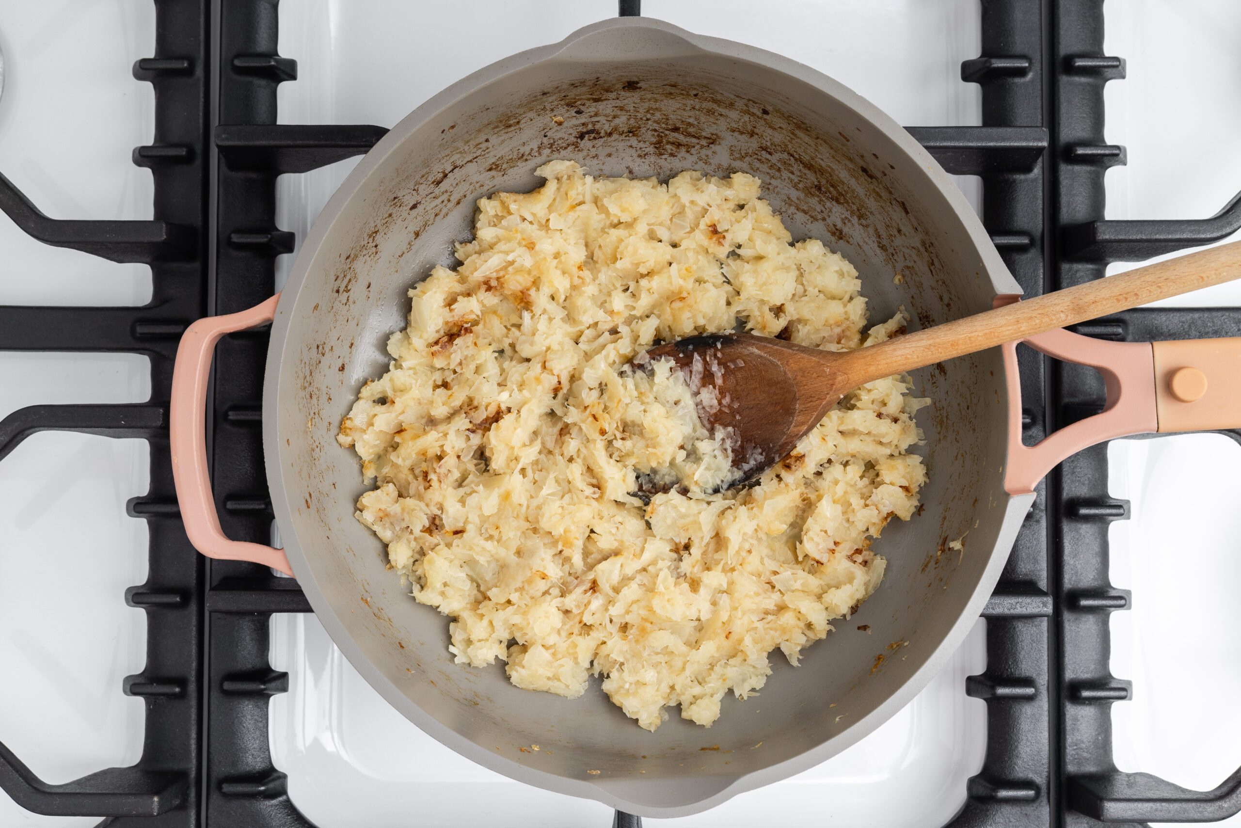 Onions being cooked in skillet.