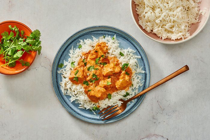 Chicken tikka masala served over basmati rice garnished with chopped cilantro