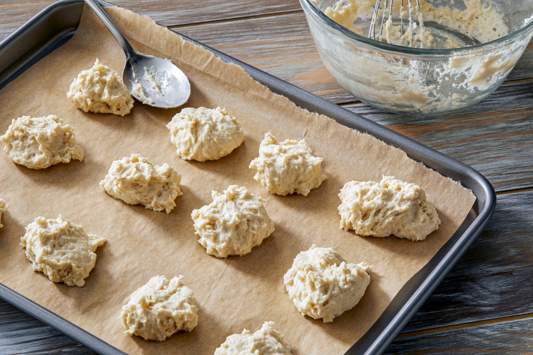3/4th shot; wooden background; Dropped rounded tablespoonfuls onto parchment lined baking sheet and set aside