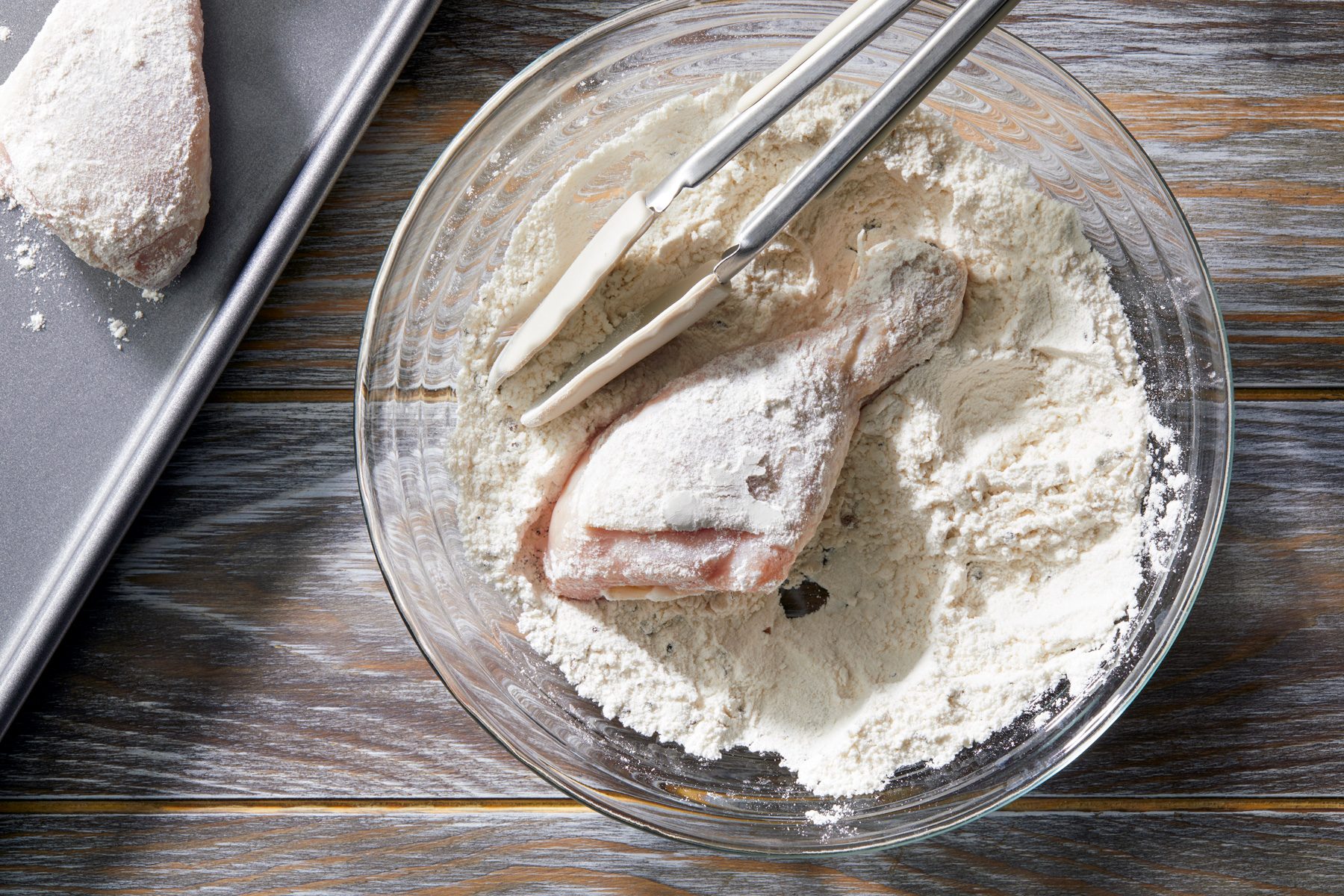 overhead shot; wooden background; In a Shallow bowl mixed half cup of flour salt and pepper added chicken one at a time to coat with the help of a tong