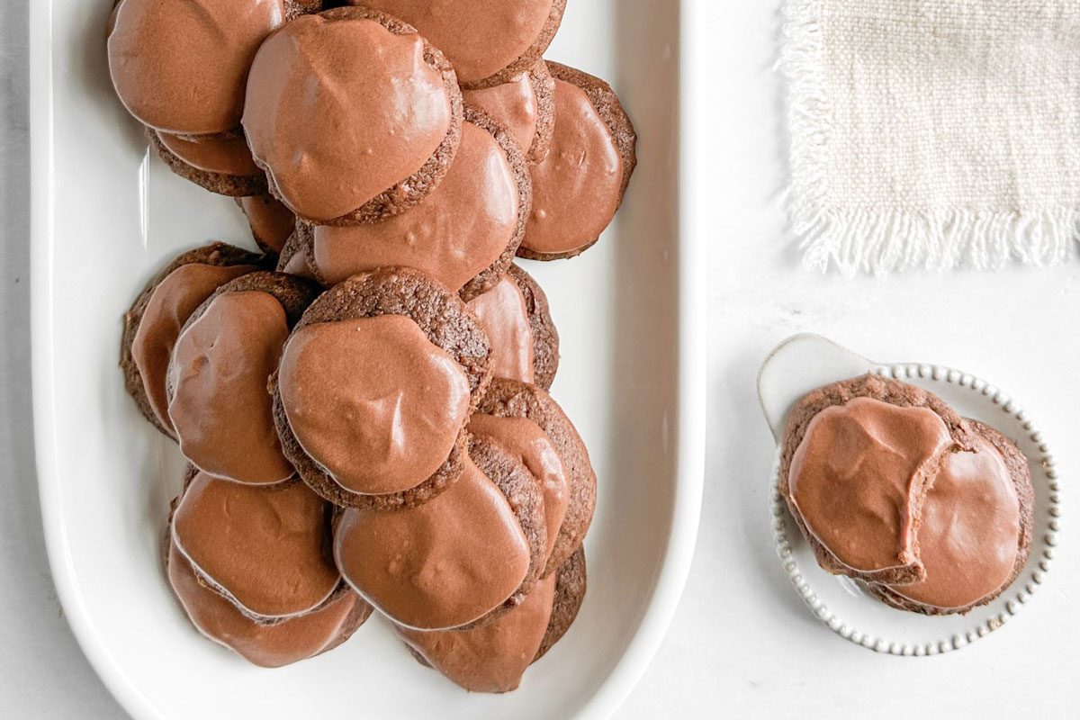 Taste of Home Chocolate Drop Cookies on white ceramic plates next to a linen napkin on a marble surface