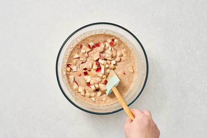 Chopped apples being stirred into the pancake batter