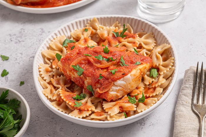 Plate With Whole Wheat Past And Cod In Tomato Sauce And Parsley