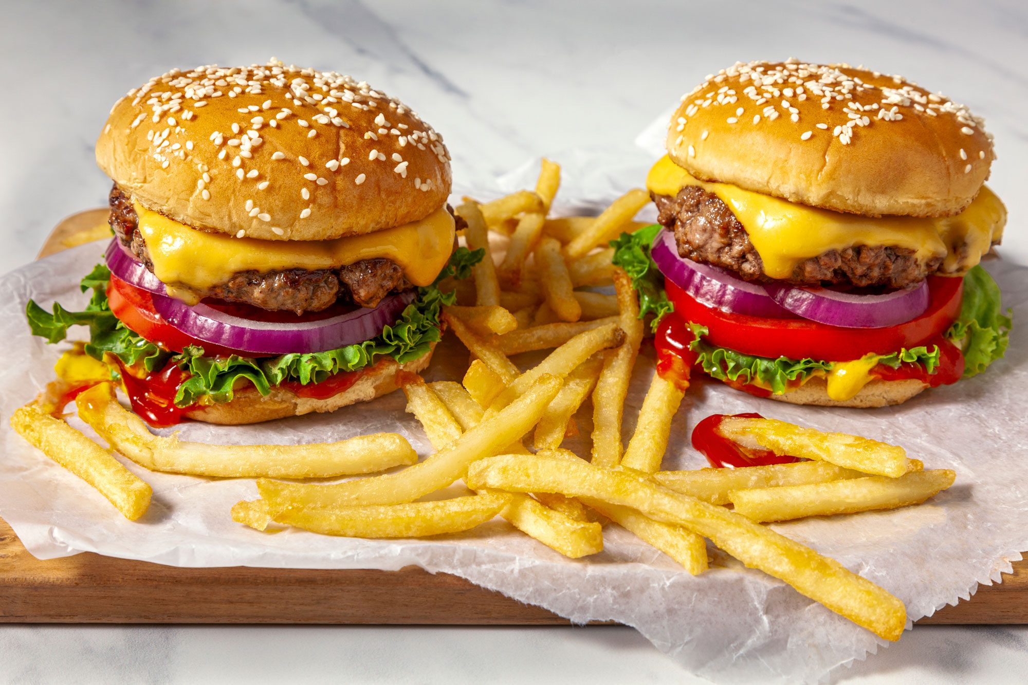 Two cheeseburgers served with French fries