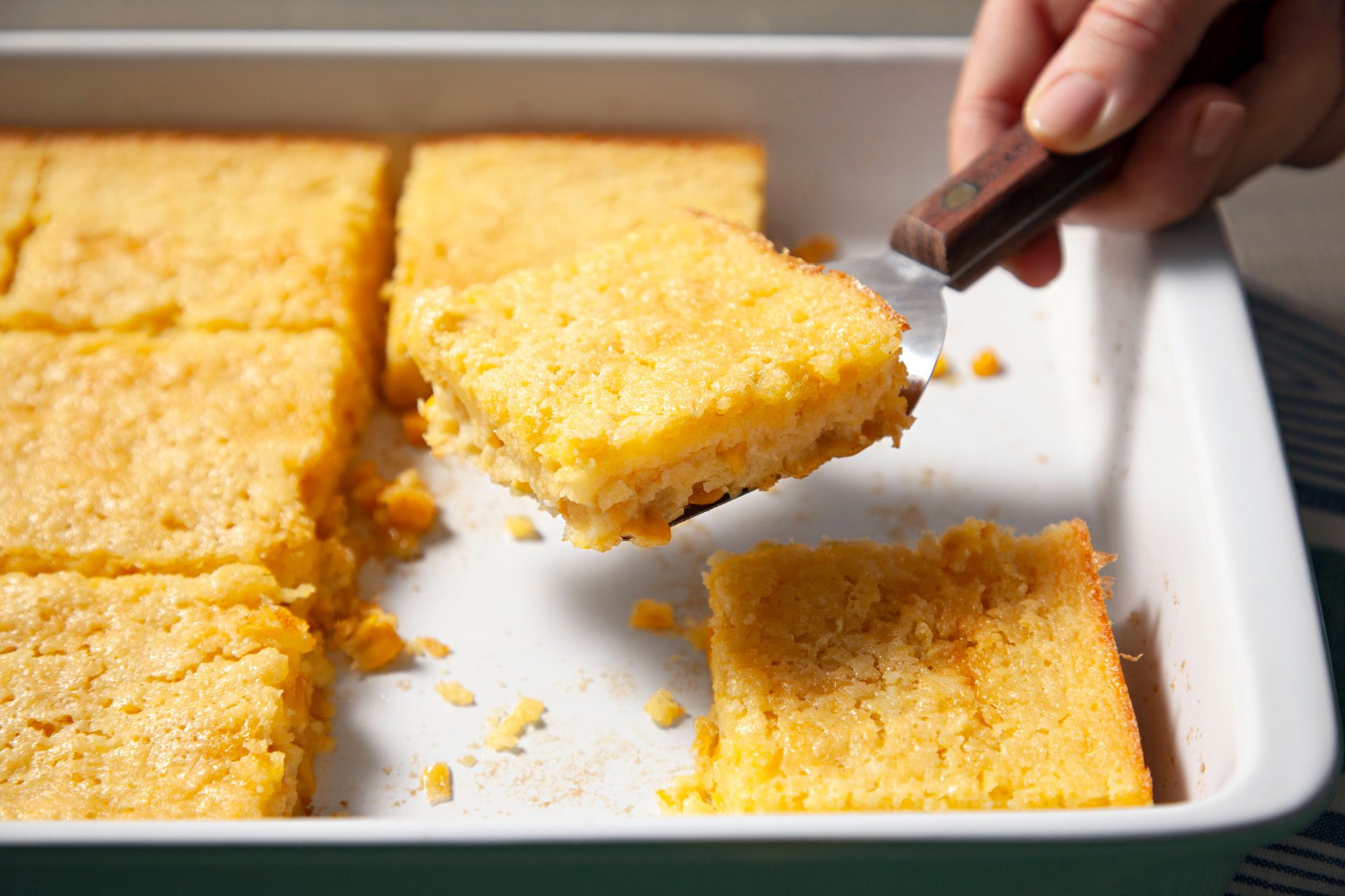 Corn Pudding cut into pieces before serving with spatula