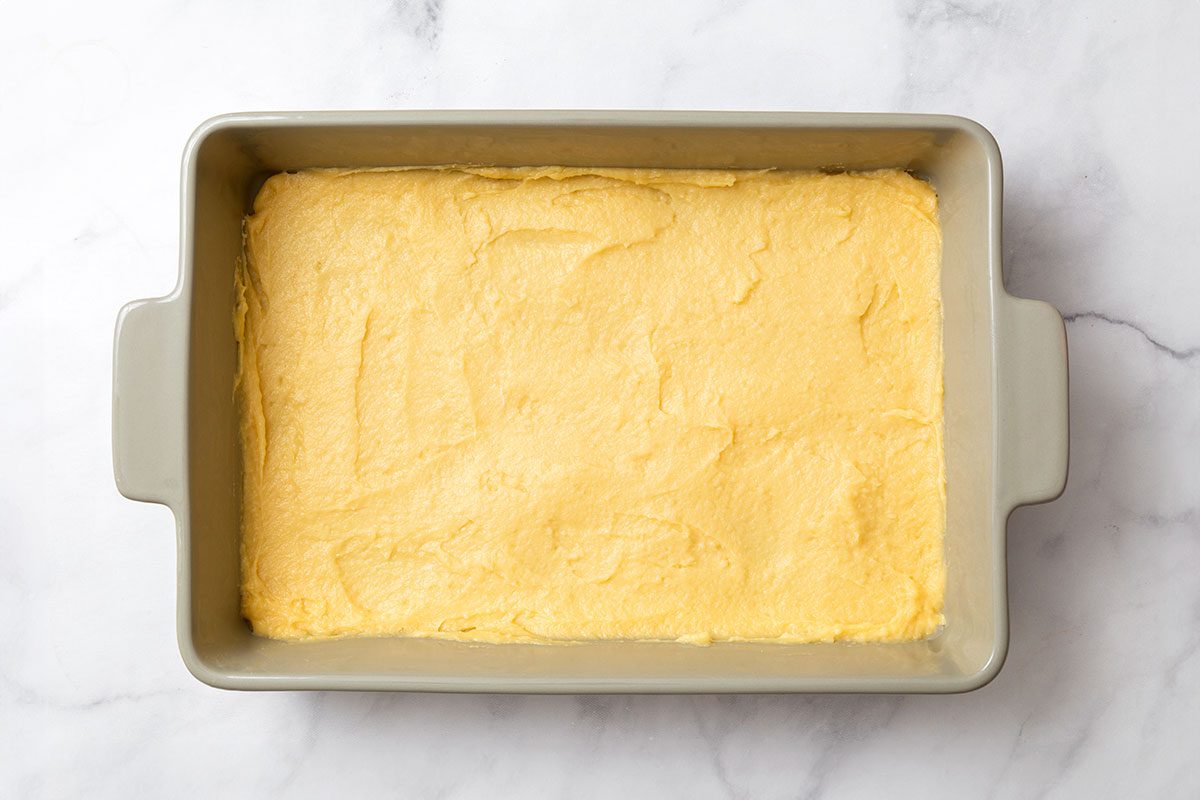 Dough in 9 by 13 baking dish for step two of Cream Puff Cake recipe for Taste of Home