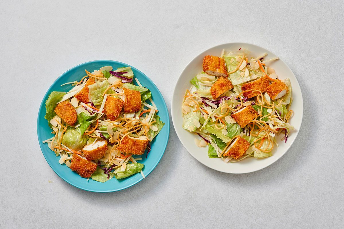 Adding chicken and toppings to the salad