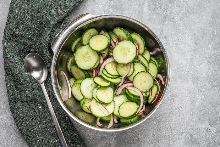 Cucumber and red onion salad preparation.