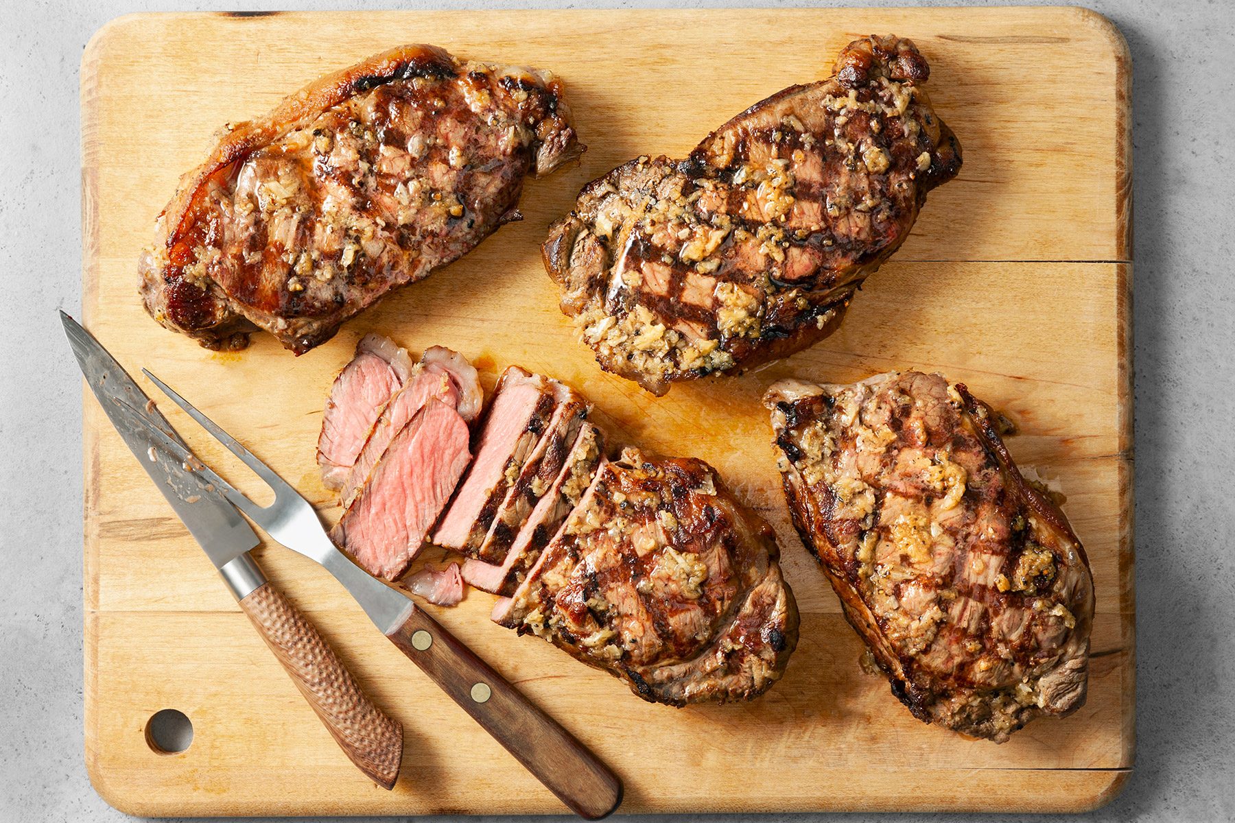 grilled steaks on a wooden plank
