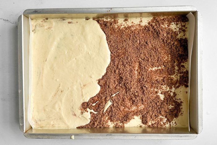 Unbaked Taste of Home Honey Bun Cake in a metal baking pan on a marble surface