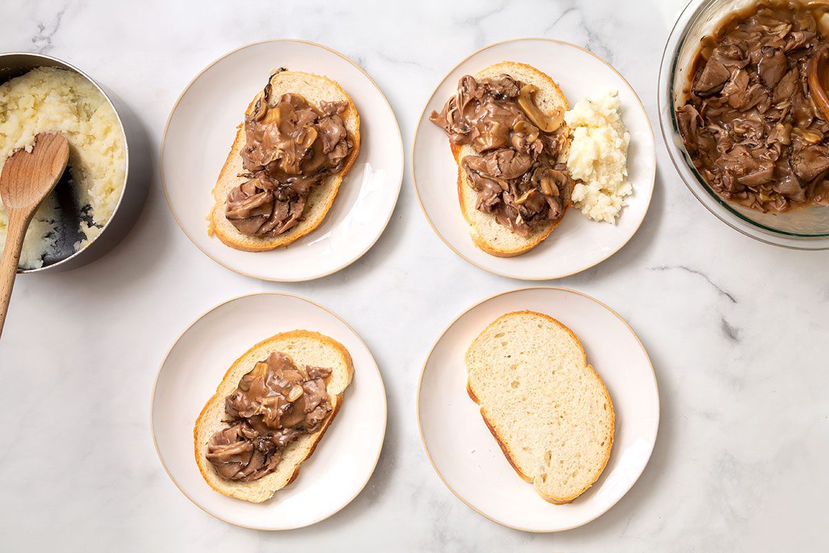Assembly of sandwiches with beef mixture on top of sliced Italian bread with a sides of mashed potatoes for step two for Hot Roast Beef Sandwich for Taste of Home