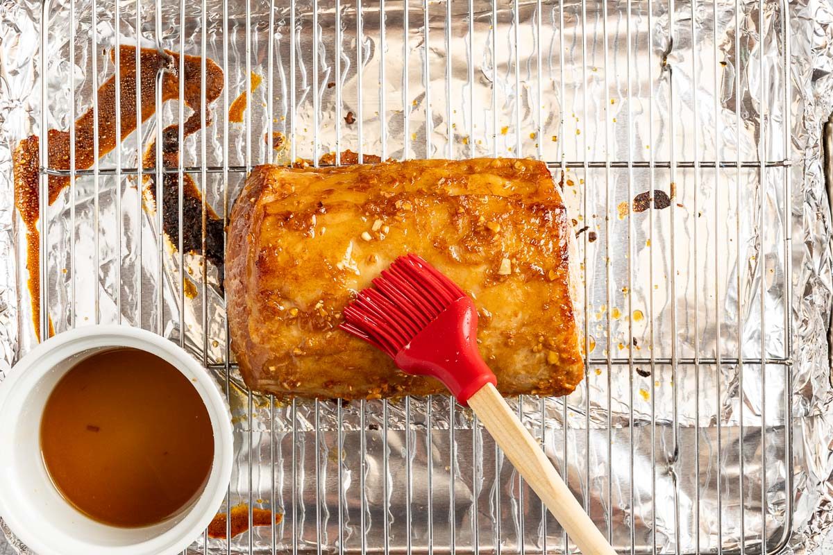 Taste of Home Marinated Pork Loin photo of the partially cooked pork loin being brushed with the glaze.
