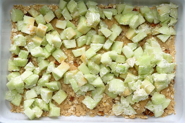 Sliced apple spread over crust ingredients.