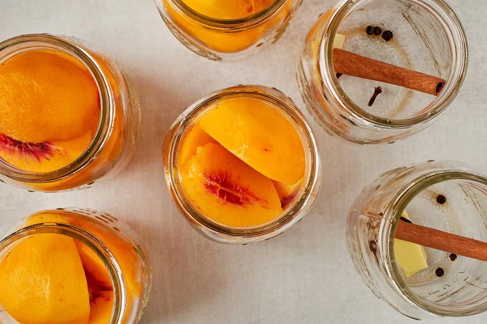 Add peaches and spices to jars