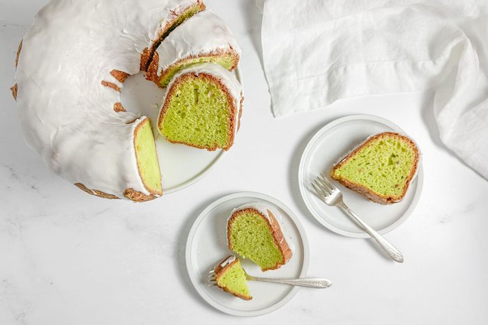 Taste of Home Pistachio Bundt Cake on white plates on a marble surface