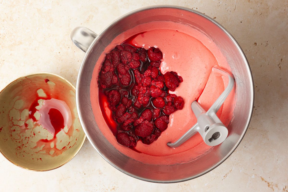 Step 1 of Taste of Home Raspberry Cake is to combine the cake mix, raspberry gelatin, eggs, canola oil and hot water in a large bowl. Beat on low speed for 30 seconds to combine the ingredients, then increase the speed to medium and beat for two minutes until the batter is smooth. Gently fold in the thawed raspberries along with their juices.