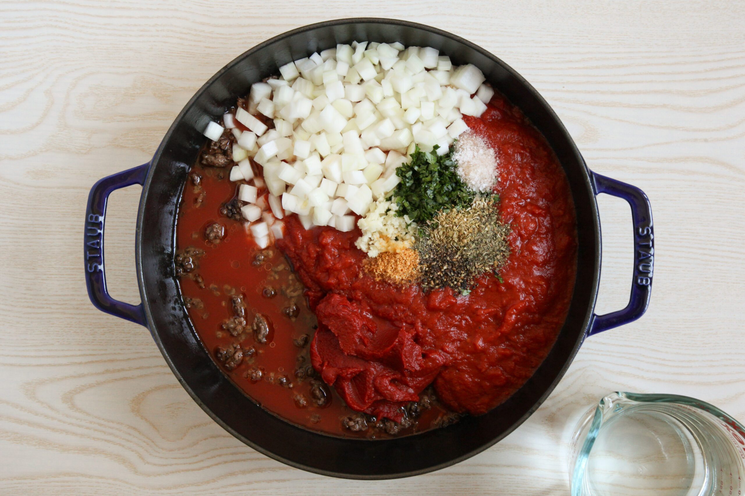 Adding Ravioli Soup ingredients to a dutch oven
