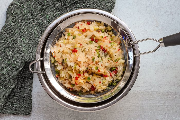 Draining chilled sauerkraut salad.