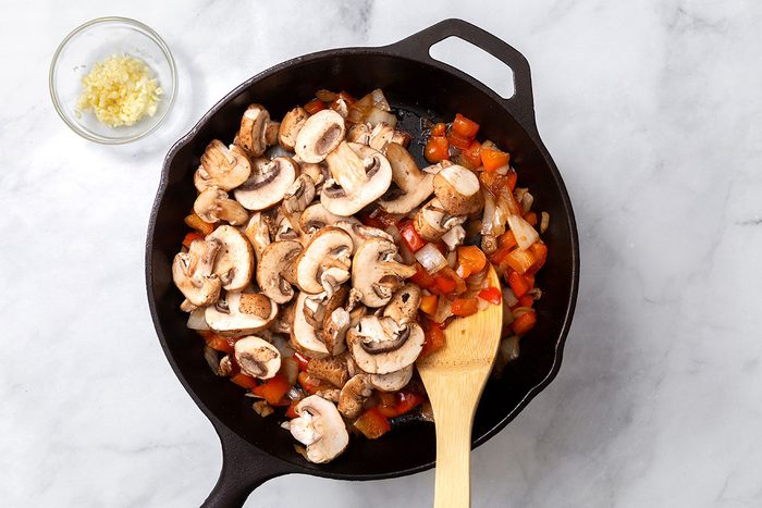 Onion, red pepper and sliced mushrooms being sauted in a large skillet for step three of Steak Pizzaiola recipe for Taste of Home