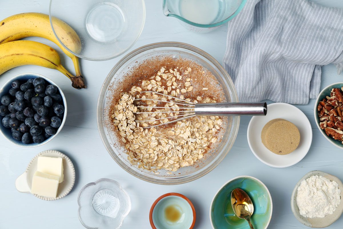 Process of making Taste of Home's Blueberry Baked Oatmeal in small dishes on a light blue surface.