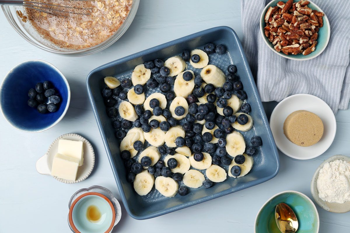 Process of making Taste of Home's Blueberry Baked Oatmeal in small dishes on a light blue surface.