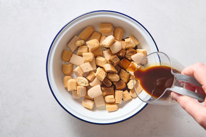 Pouring coffee over ladyfingers