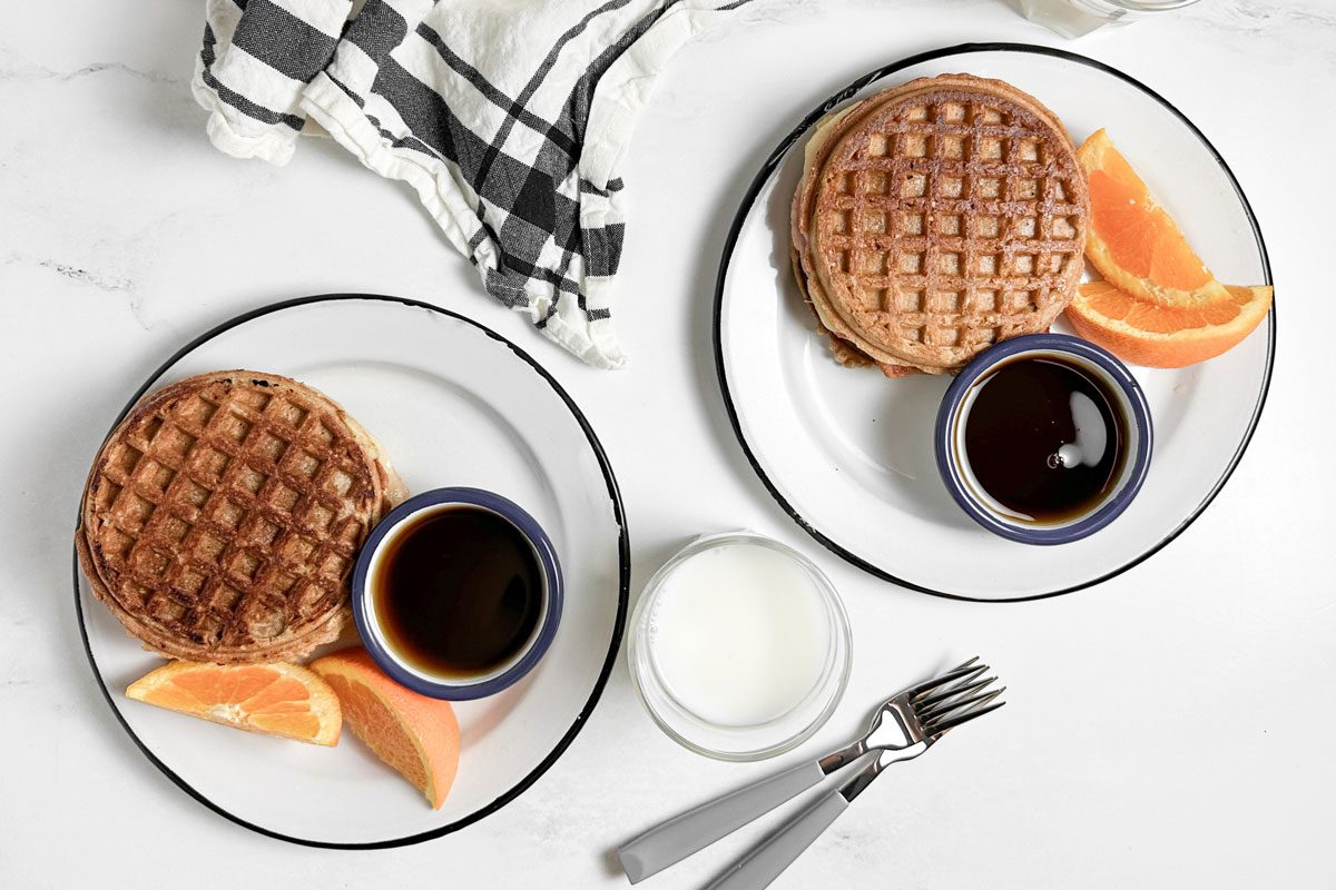 Taste of Home Waffle Sandwich on enamel plates with orange wedges and maple syrup