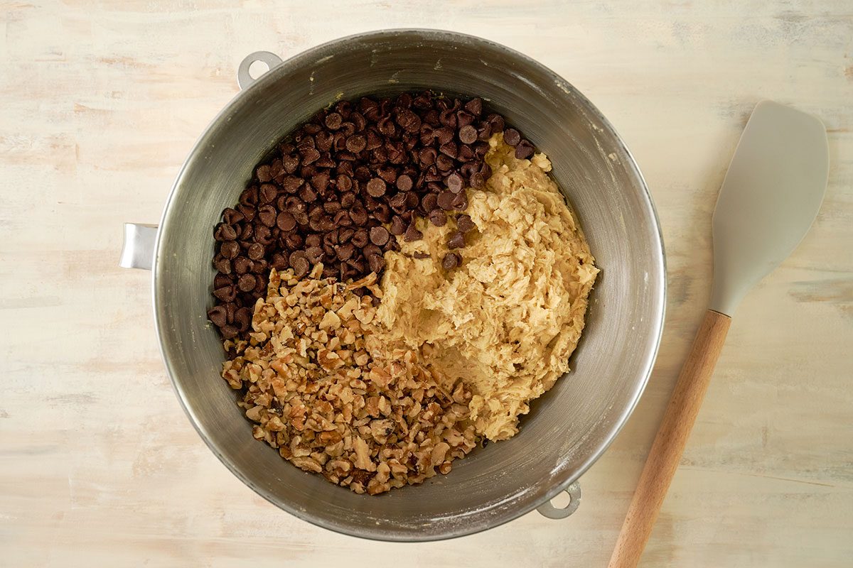 Overhead view of semisweet chocolate chips and chopped nuts being folded into the oatmeal cookie dough for the Taste of Home Air Fryer Oatmeal Cookies recipe.