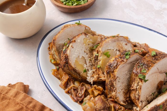 Apple pork loin ready and served with fresh parsley to garnish.