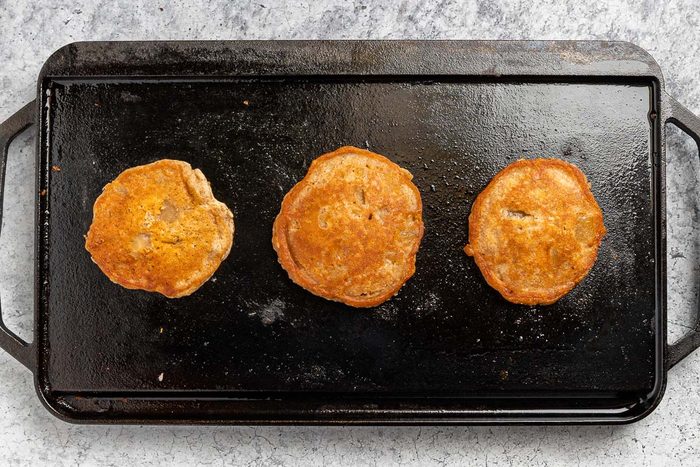 Cinnamon Applesauce Pancakes on the griddle