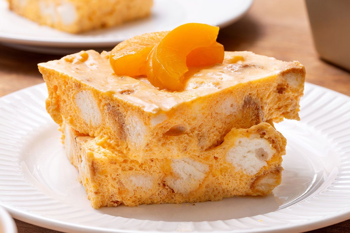 Stacked pieces of Apricot Delight topped with apricot slices on a plate for Taste of Home