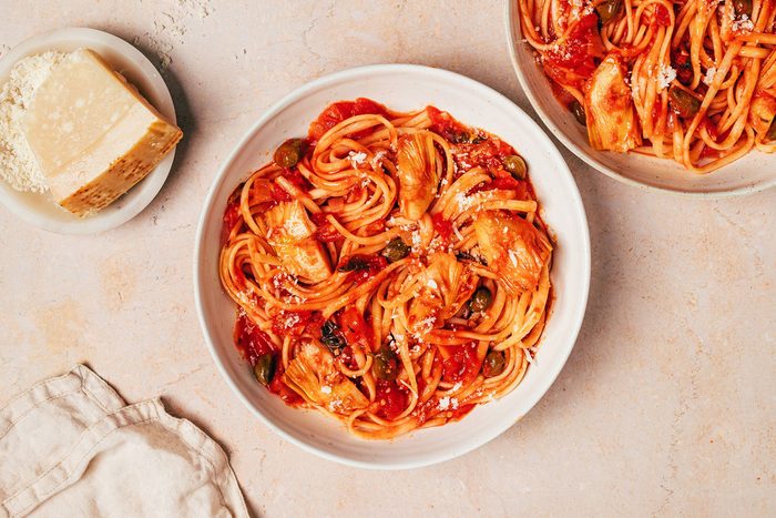 Two bowls with Artichoke Tomato Pasta topped with grated parmesan recipe by Taste of Home