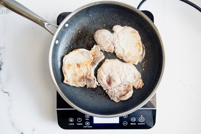 Overhead shot for Taste of Home BBQ Pork Chops in a HexClad pan over an induction cooktop.
