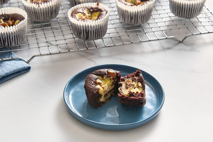 Closeup of a single black bottom cupcake on a plate split in two