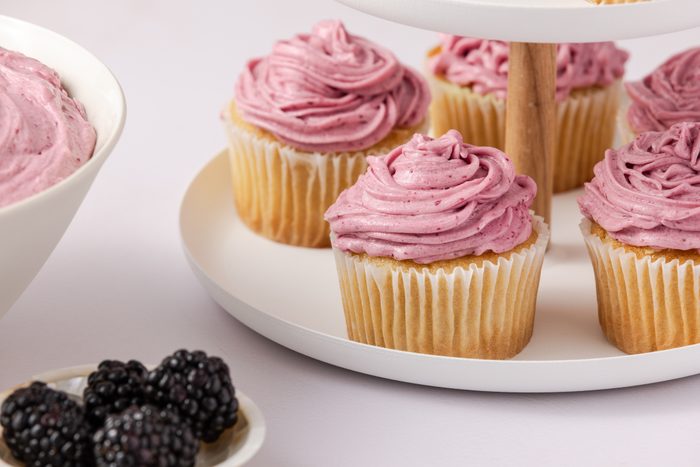 Close up of cupcake frosted with blackberry buttercream.