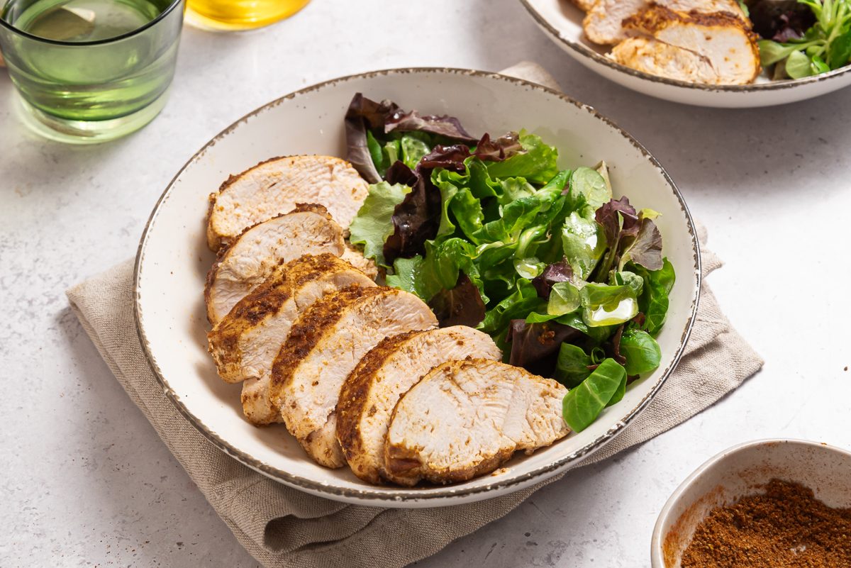 Plates With Sliced Blackened Chicken And Salad