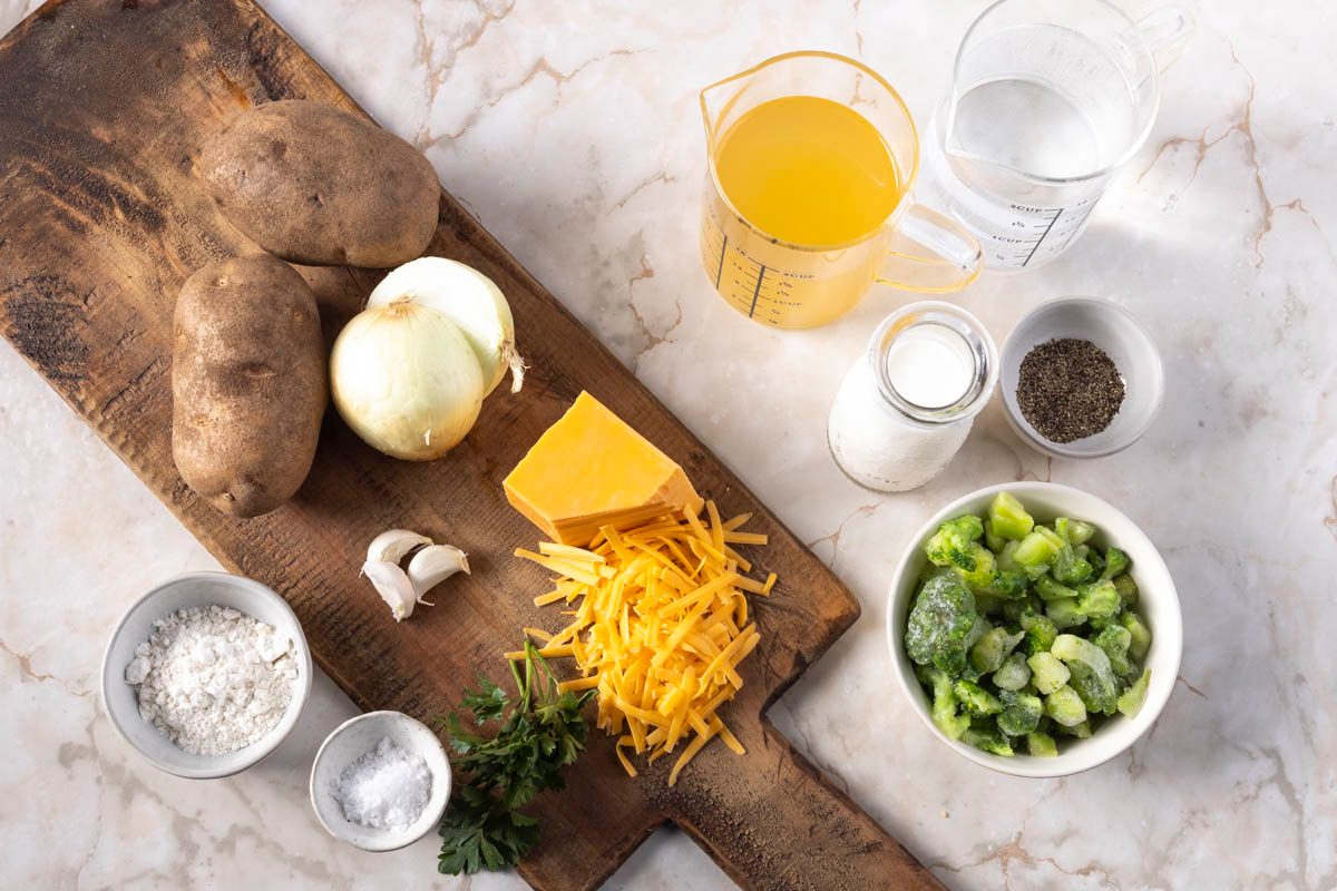 Ingredients for Broccoli Cheddar Potato Soup photographed overhead on a marble surface