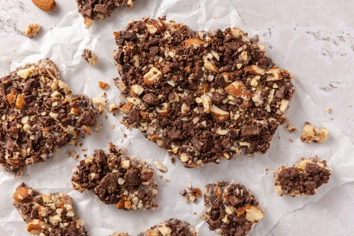 Butter toffee broken into pieces on parchment paper.
