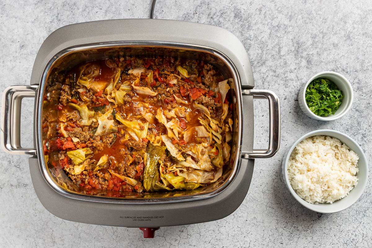 all the ingredients combined in the slow cooker with rice and parsley to serve.