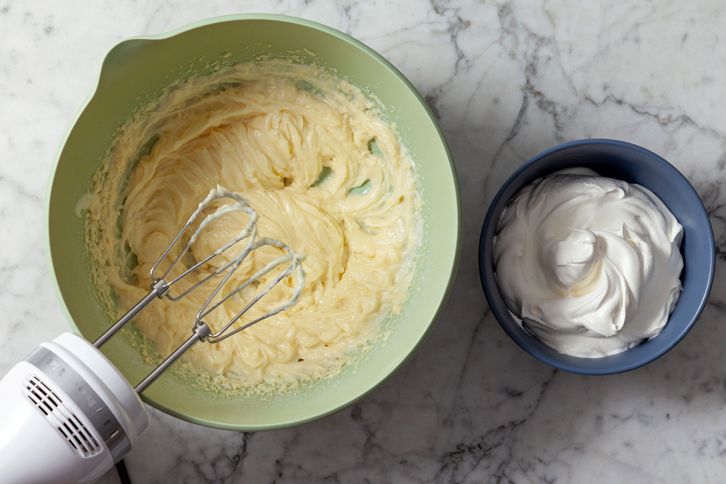 Beating pudding mix and yogurt in a large bowl to make Cheesecake Fruit Salad