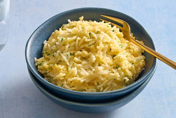 Angled shot of a bowl of cheesy rice with a fork