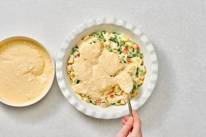 Spooning biscuit topping over the pie filling