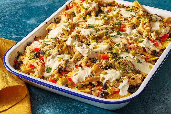 Closeup of chicken nachos baked in a large baking tray