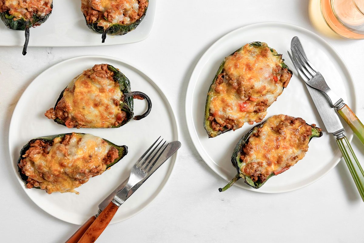 Taste Of Home Chili Stuffed Poblano Peppers On White Plates