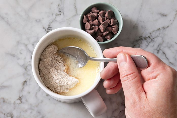 Flour, brown sugar, baking powder and salt being mixed into milk.