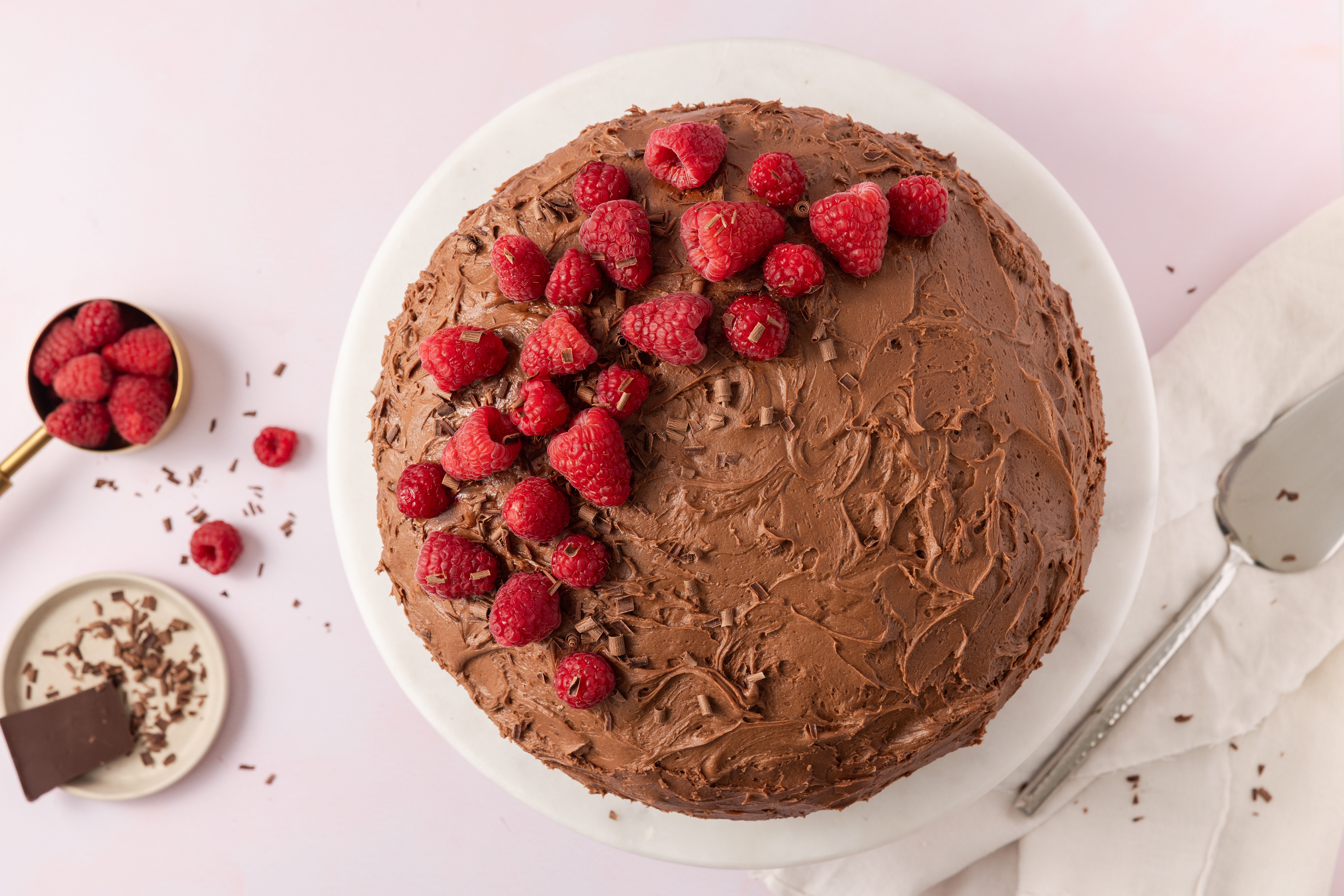 Chocolate raspberry cake ready on cake stand.