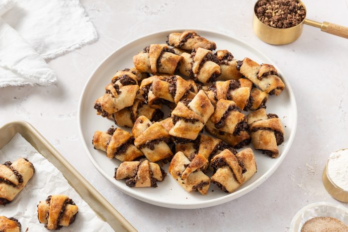 Chocolate rugelach ready served on plate and baking tray.