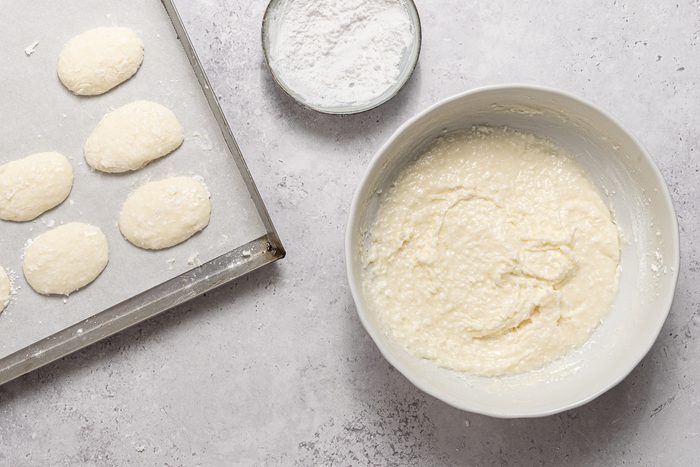 Bowls With Cream Cheese And Coconut Batter And Pan With Easter E