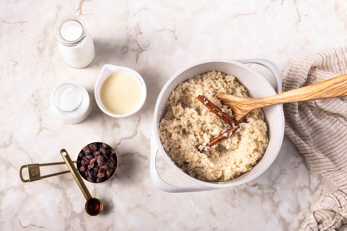 Stir in the milk, condensed milk, coconut milk, raisins and vanilla. for Coconut Rice Pudding overhead on marble